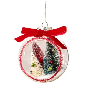 Transparent Christmas ball ornament with mini bottle brush trees and red velvet bow decoration.