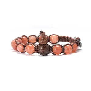 Gros plan détaillé du bracelet de perles en pierre naturelle avec pendentif gourde en bois.