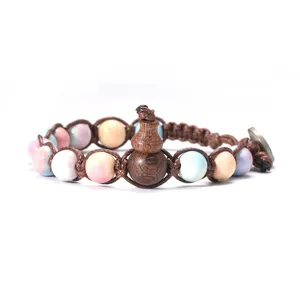 Gros plan détaillé d'un bracelet en corde tressée avec des perles colorées et pendentif gourde.