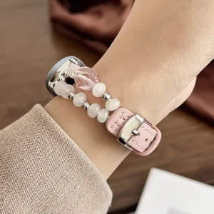 Dettaglio del cinturino in pelle con perle di cristallo rosa e fibbia in metallo lucido.
