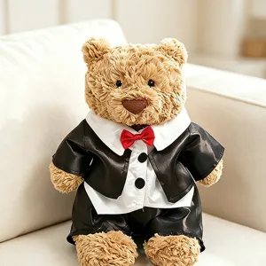 Niedlicher Teddybär Plüschtier mit klassischem schwarzem Smoking, rote Fliege, Nahaufnahme.