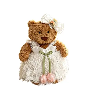 Süßer brauner Plüsch Teddybär mit elegantem weißem Kleid und schöner Haarschleife.
