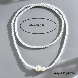 Dettaglio della collana di perle a doppio strato con elegante design a perla grande asimmetrica.