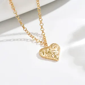 Gold hammered heart pendant necklace close-up, delicate French vintage chain jewelry detail view