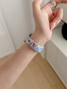Woven watch strap with cute bear and metal charm, stylish replacement band for smartwatch.