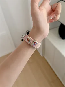 Pink braided smartwatch strap featuring a cute bear pattern and metal buckle. Replacement band for daily wear.