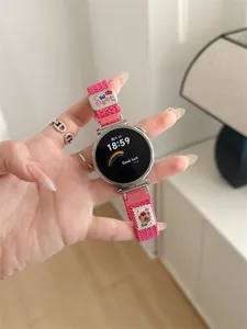 Detailed view of a vibrant pink braided smartwatch strap featuring a cute bear charm and sweet tag.