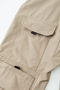 Primo piano di pantaloni cargo sottili da uomo con tasche multiple e tessuto ripstop resistente.