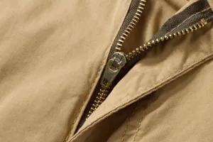 Close-up detail of durable metal zipper and twill fabric on men's casual cargo work pants.