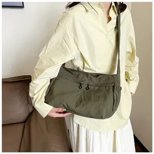 Detailed view of casual nylon crossbody bag showing front zipper pockets and sturdy shoulder strap.