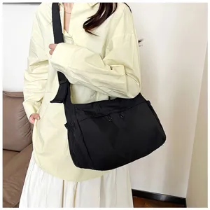 Detail view of the black nylon utility crossbody bag, showing spacious capacity and daily wear.