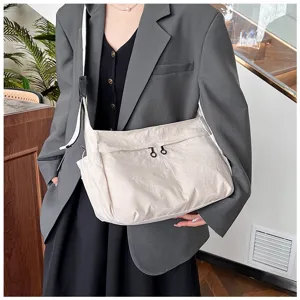 Detailed view of the casual nylon crossbody bag featuring front utility pockets and zippers.