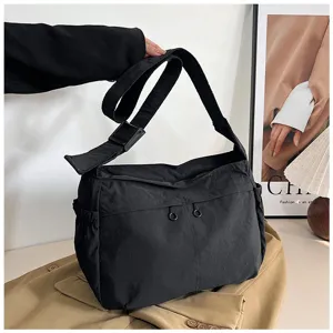 Detailed shot of casual black nylon messenger bag, showcasing large capacity and utility style.