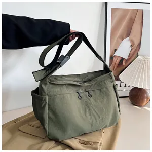 Nylon crossbody bag detail, utility style shoulder bag with zipper pockets and adjustable strap.