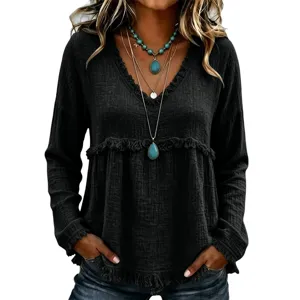Detailed view of women solid black long sleeve V-neck blouse with frayed fringe edges.