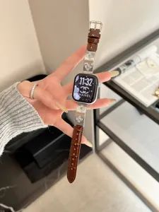 Detailansicht des braunen Lederarmbands mit Kleeblatt-Anhängern für Smartwatch, eleganter Stil.