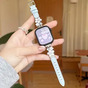 Close-up detail of light blue leather watch strap featuring elegant silver metal floral charms.