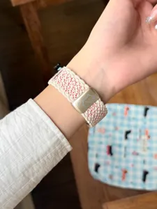 Vue détaillée du bracelet de montre en nylon tressé avec boucle métallique de chat mignon.