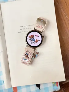 Vue détaillée du bracelet de montre en nylon tissé avec charmante broderie de chiot.