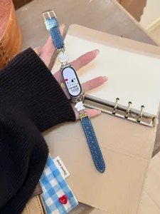 Detailansicht des stilvollen Jeans-Smartwatch-Armbands mit süßen Metallwelpen-Anhängern im Alltag.