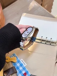 Detailansicht des niedlichen Welpen Cartoon Design Jeans Leder Smartwatch Armband mit Metallkette.