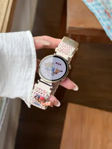 Vue détaillée du bracelet de montre en nylon tressé avec joli design de chiot et boucle métallique.