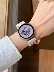 Gros plan détaillé du bracelet de montre en nylon tissé porté au poignet avec breloque.
