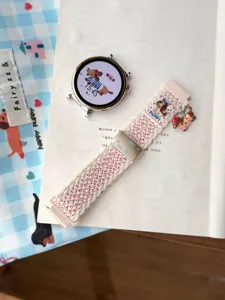 Vue détaillée du bracelet de montre en nylon tressé avec charmant pendentif chiot et boucle.