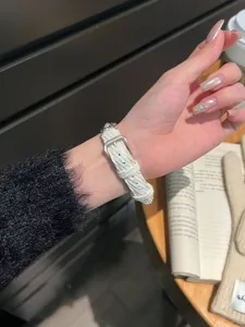Vue détaillée du bracelet de montre en velours côtelé avec boucle en métal et sangle.