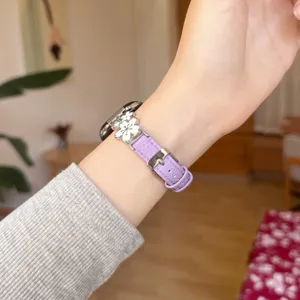 Metal flower leather watch strap detail view, elegant purple replacement band for Apple Watch.
