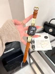 Detailaufnahme des luxuriösen braunen Lederarmbands mit funkelnden vierblättrigen Kleeblatt-Charms.