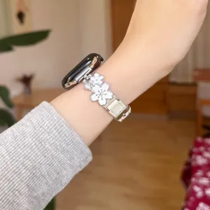Detail view of metal flower Apple Watch strap, featuring elegant floral charms and premium leather.