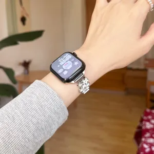 Metal flower watch strap compatible with Apple Watch Series, stylish wrist accessory.