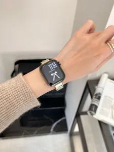 Detailansicht des luxuriösen Metallarmbands mit Kleeblatt-Motiv für Apple Watch. Elegantes Design.