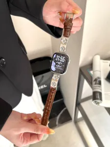 Nahaufnahme des kleeblatt-metall-dekorierten braunen lederarmbands kompatibel mit apple watch.