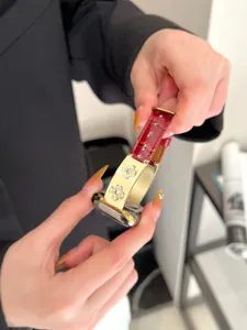 Detailansicht des roten Leder- und Gold-Kleeblatt-Strass-Apple-Watch-Armbands, elegantes Zubehör.
