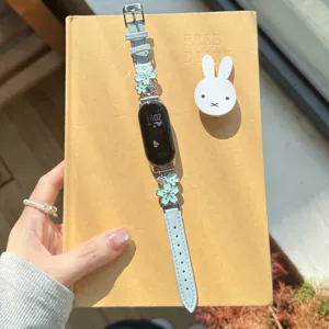 Elegant floral leather watch band with metal charm details, exquisite accessory for smartwatches.