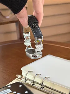 Detailansicht des Jeans-Leder-Smartwatch-Armbands mit süßen weißen Bären-Metallanhängern.