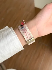 Vue détaillée de bracelet de montre en nylon tressé avec charm chiot pour montre connectée.