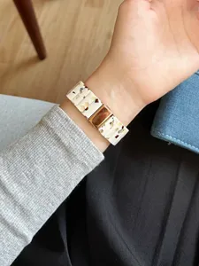 Detailansicht des Kunstharz-Uhrenarmbands mit auffälligem Schildpatt-Muster am Handgelenk getragen.