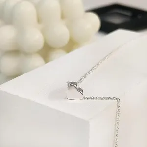 Collana con ciondolo a cuore argento minimalista dettaglio, gioiello catena metallo primo piano