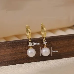 Close-up view of elegant gold-plated pearl drop earrings featuring sparkling cubic zirconia.
