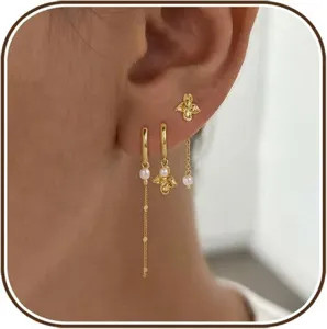 Detailed close-up of a multi-piece gold plated pearl earring set worn on the ear, elegant style.