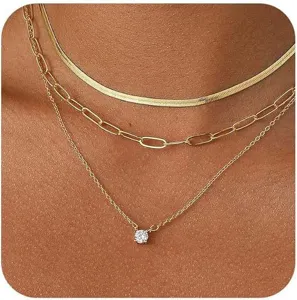 Collana dorata multistrato con ciondolo in zircone delicato e catene per uno stile elegante.
