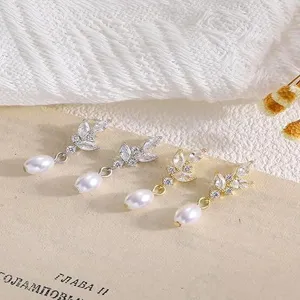 Primo piano dettagliato di orecchini di lusso con zirconi e perle. Vetrina di gioielli raffinati.