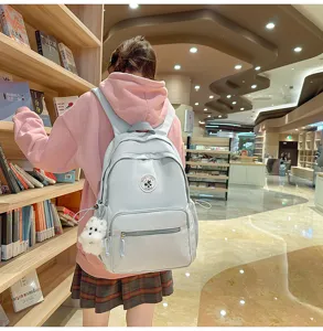 Zaino minimalista monocolore di grande capacità per donne e studenti con ciondolo cane di peluche.