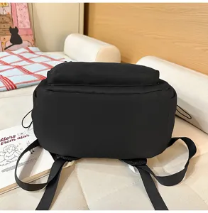 Vista dettagliata di uno zaino casual nero minimalista con spallacci regolabili e tasca.