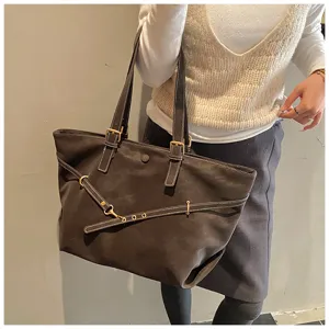 Gedetailleerd overzicht van de matte bruine shopper met metalen gespen en handige bandjes.