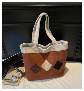 Detail view of a stylish brown corduroy tote bag with diamond patches and large capacity.