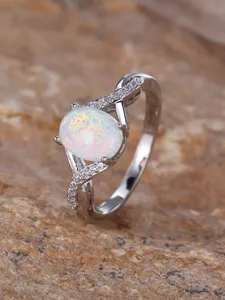 Elegant sterling silver cross twisted ring featuring a glowing oval white opal and sparkling stones.